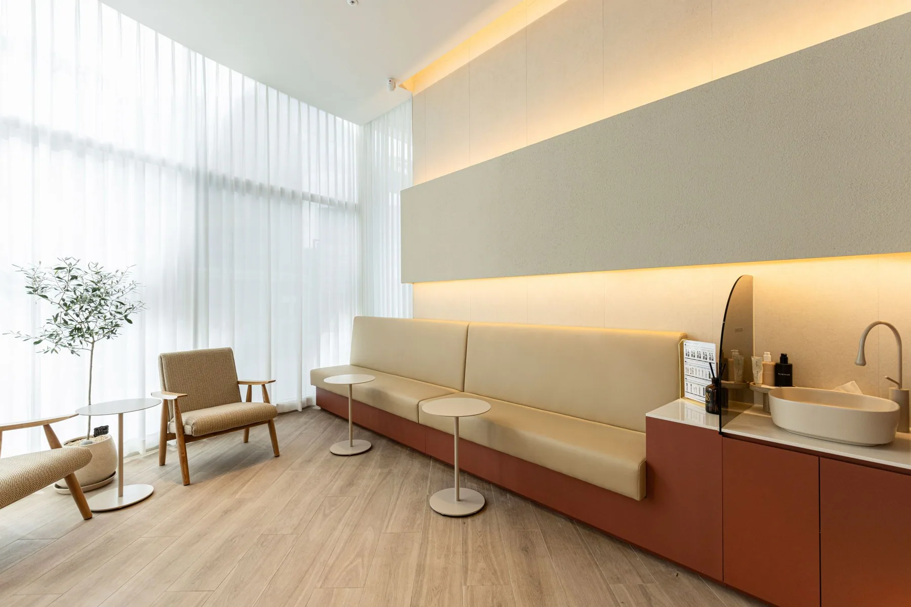 Sofa and tables by a window with white curtains